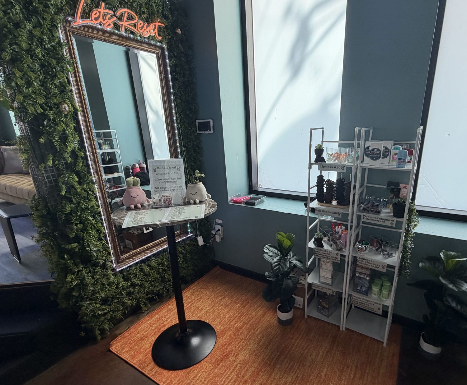 The SpaceCity Essentials setup at Reset in Midtown Houston, with stocked shelves, a mirror, and greenery